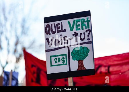 A homemade French sign, saying what green do you see, is viewed close-up, held by an environmentalist during a march in Montreal, Canada