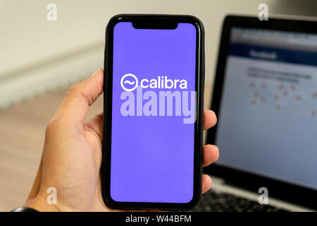 12 July 2019, Ljubljana Slovenia - Hand holding smartphone with Calibra logo on it. Facebook's new global cryptocurrency for transactions Stock Photo