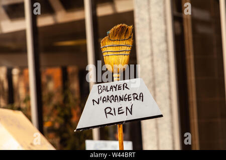 A sign attached to a broom is viewed close-up, saying sweeping does not help, as environmental activists stage a street demonstration in the city