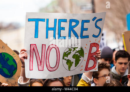 A colorful poster is held above the heads of ecological activists, saying there's no planet b, during a crowded march for the environment Stock Photo