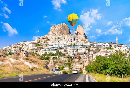 Uchisar castle, one of the most famous landmark in Turkey and one hot air balloon getting close to the castle. Stock Photo