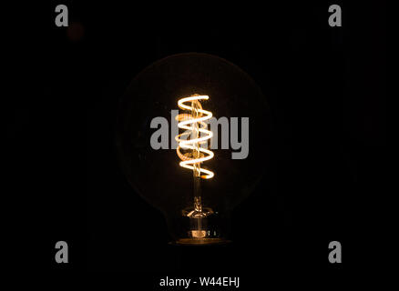 Lightbulb on dark background with bright spiral wire Stock Photo