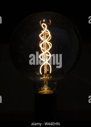 Lightbulb on dark background with bright spiral wire Stock Photo