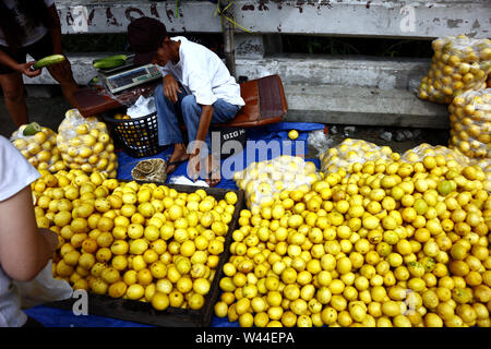 ANTIPOLO CITY, PHILIPPINES – JULY 17, 2019: A street vendor sells fresh and ripe lemon at a sidewalk along a highway. Stock Photo