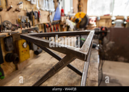 A closeup view on the triangular top of a geometric metal frame created inside a blacksmith's workshop. Finished product of a metalworker. Stock Photo