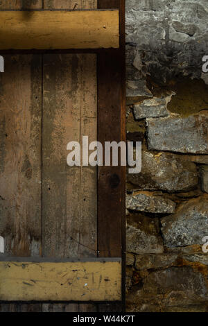 Old wooden door and stone wall in old warehouse basement. Stock Photo