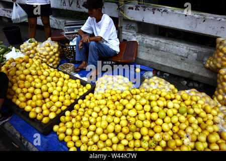 ANTIPOLO CITY, PHILIPPINES – JULY 17, 2019: A street vendor sells fresh and ripe lemon at a sidewalk along a highway. Stock Photo
