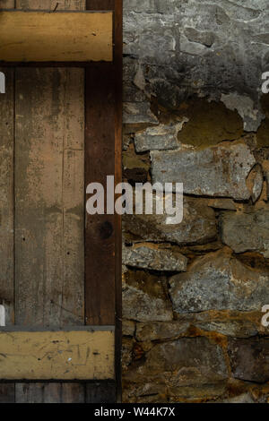 Old wooden door and stone wall in old warehouse basement. Stock Photo