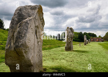 Ancient standing stones at the South West Sector of Avebury Henge with bank and ditch with Fowlers cottage Avebury Wiltshire England Stock Photo