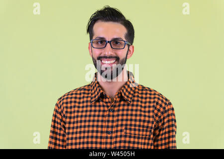 Face of happy young bearded Persian hipster man smiling Stock Photo