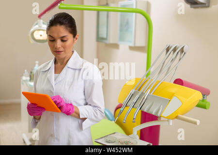 Focused female doctor standing near a dental drill Stock Photo