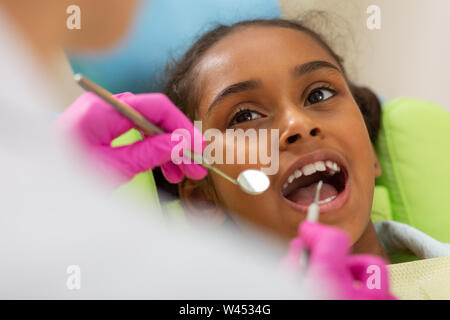 Cute young girl sitting with an open mouth Stock Photo