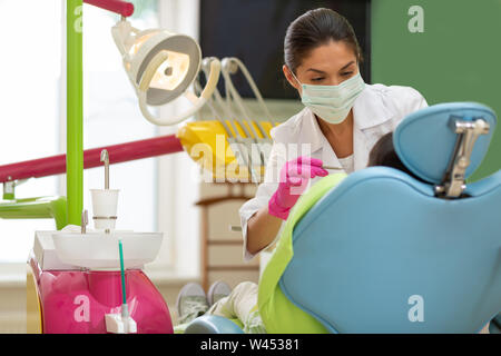 Serious female dentist standing near a dental drill Stock Photo