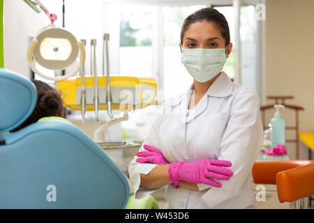 Serious middle-aged female doctor in a green mask Stock Photo