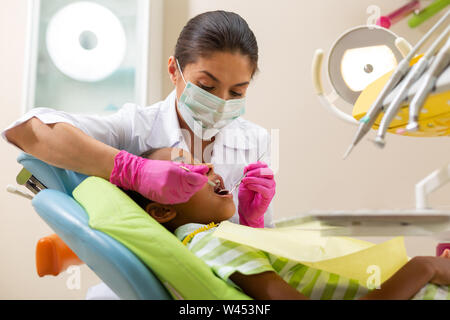 Serious Caucasian female dentist performing a dental exam Stock Photo