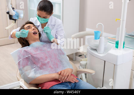 Dentist putting the dental braces on her patients teeth Stock Photo