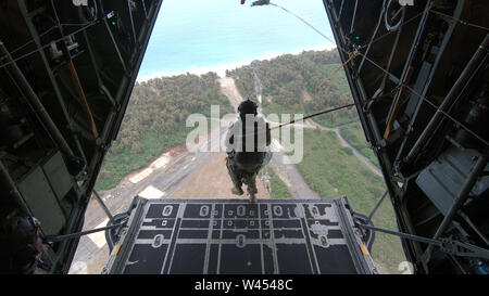 A U.S. Air Force Special Tactics Airman assigned to the 22nd Special Tactics Squadron, Joint Base Lewis-McChord, Washington, conducts a static line jump from a C-130H Hercules aircraft during training at a range on Marine Corps Base Hawaii, June 24, 2019. Special Tactics is a special operations ground force comprised of highly trained Airmen who solve air to ground problems across the spectrum of conflict and crisis. (U.S. Air Force photo by Staff Sgt. Rose Gudex) Stock Photo