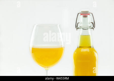 Freshly blended Manchurian mushroom tea is seen closeup, in a glass bottle and stemmed glass, isolated against a white background. Versatile health drink. Stock Photo