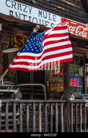 American flag waving from the front porch of Crazy Mule Antiques in Lula, Georgia. (USA) Stock Photo