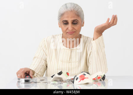 Disappointed woman with broken piggy bank Stock Photo