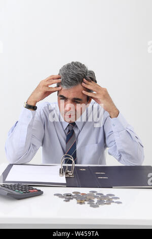Depressed businessman working out finances Stock Photo
