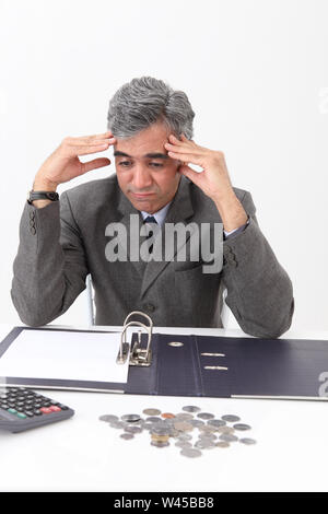 Depressed businessman working out finances Stock Photo