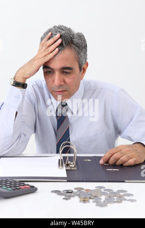 Depressed businessman working out finances Stock Photo