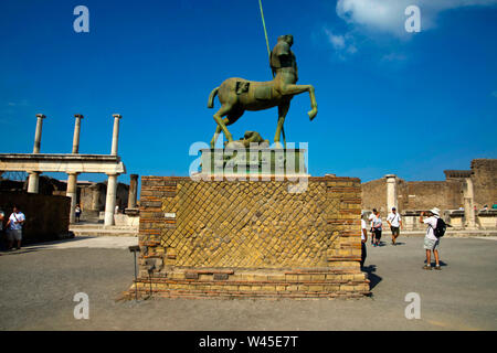 POMPEII, ITALY, July 2018, Tourist at stature of a centaur in bronze on a decorative brick platform. Stock Photo