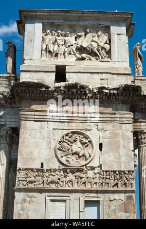 A battle scene and a frieze of soldiers on the three arched gate of the Colosseum, Rome. Stock Photo