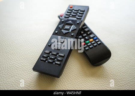 Two tv remote controls on white background Stock Photo