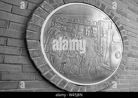 A large bronze medallion dipicting Rosa Parks boarding the bus in 1955 displayed outside the Rosa Parks Libary and Museum in Montgomery, AL, in black Stock Photo