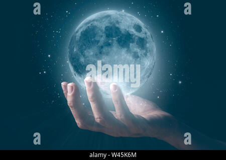 The moon hold by a human hand. Stock Photo