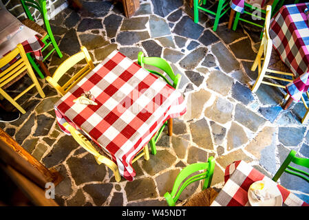 Above view of table with yellow and green chairs on stone made floor Stock Photo