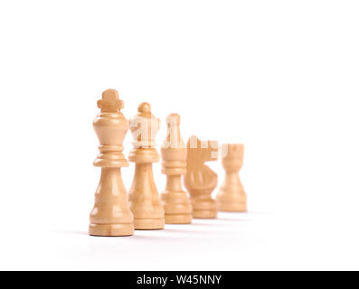 Row of white wooden chess pieces with selective focus isolated on white background. Stock Photo