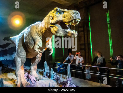 London, United Kingdom, 19 July 2019. Visitors to the Natural History Museum admire a robotized life-sized model of a Tyrannosaurus Rex dinosaur.  Pho Stock Photo