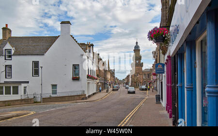 FORRES MORAY SCOTLAND LOOKING TOWARDS TOLBOOTH BUILDING AND MARKET CROSS IN THE HIGH STREET WITH HANGING BASKETS FULL OF FLOWERS Stock Photo