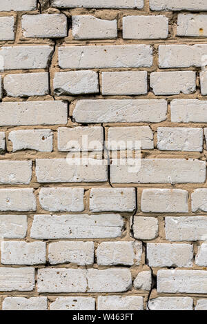 Deep cracked white silicate brick wall closeup texture and background. Vertical shot. Stock Photo