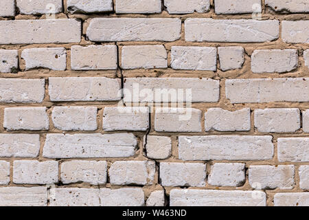 Deep cracked white silicate brick wall closeup texture and background. Horizontal shot. Stock Photo