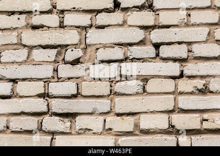 Deep cracked white silicate brick wall closeup texture and background. Horizontal shot. Stock Photo