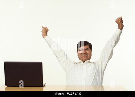 Businessman stretching in an office Stock Photo