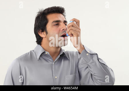 Man using asthma inhaler Stock Photo