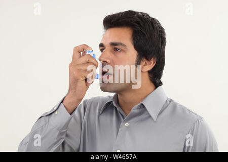 Man using asthma inhaler Stock Photo