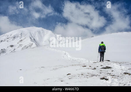 Man wearing helmet looking away and thinking in snow mountain hill scenery Stock Photo