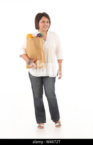 Woman holding grocery bag and smiling Stock Photo