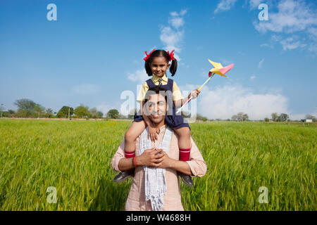 Man carrying his daughter on his shoulders Stock Photo