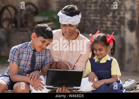Man using laptop with his children Stock Photo