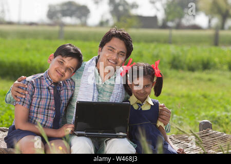 Man using laptop with his children Stock Photo