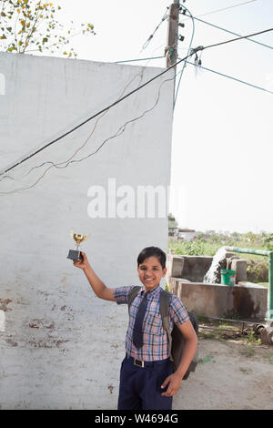 Portrait of a schoolboy holding a trophy Stock Photo