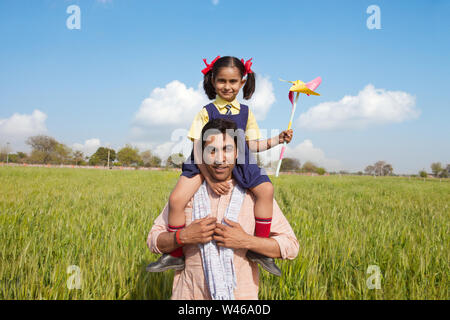 Man carrying his daughter on his shoulders Stock Photo