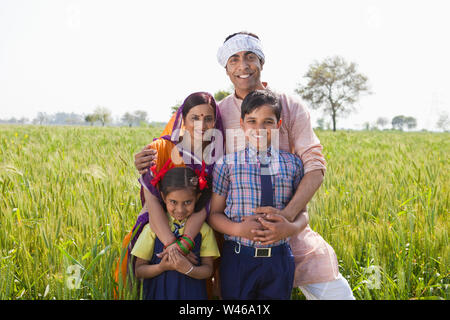 Rural family standing in a field and smiling Stock Photo